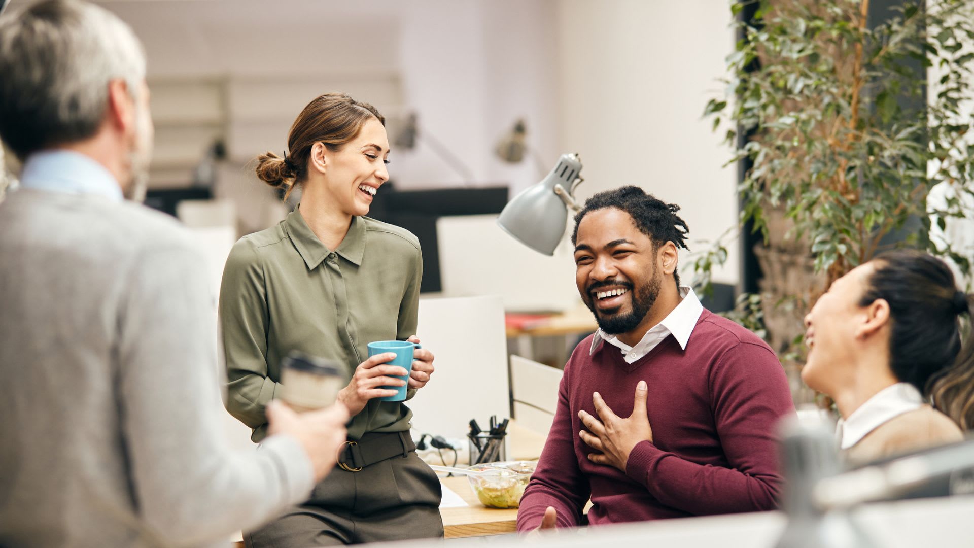 A group of people engaged in a discussion in an office setting, exchanging ideas and communicating with each other.