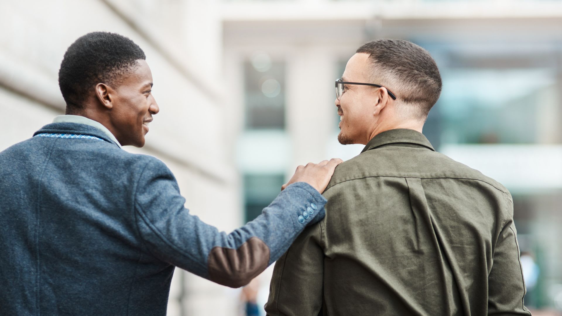 Two men walking while one places a hand on the other's shoulder, symbolizing a successful business partnership.