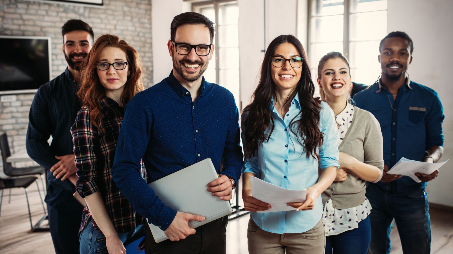 A diverse group of professionals standing in a modern office setting.