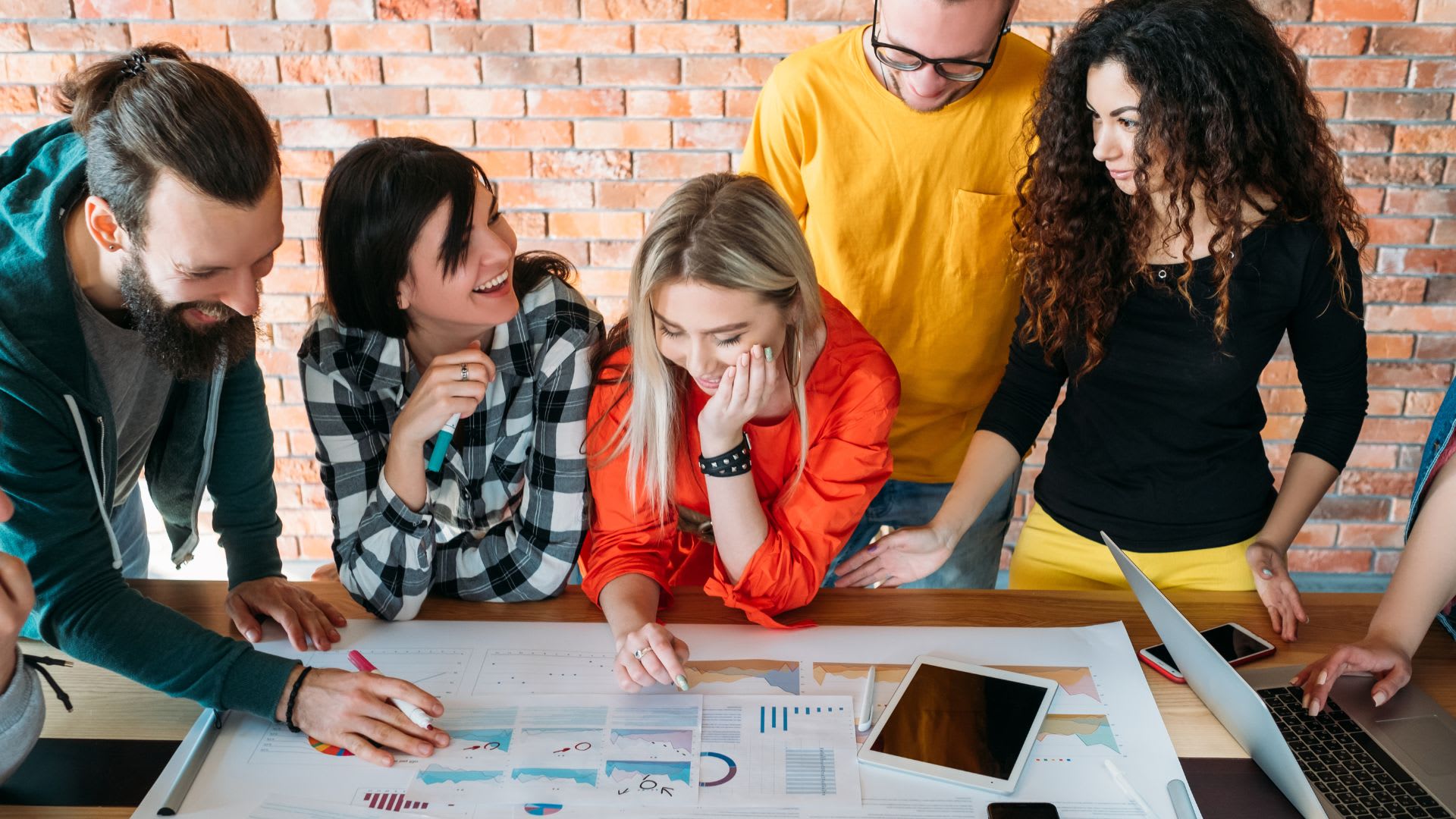 A team of young professionals working collaboratively on a project, demonstrating teamwork and innovative thinking in a shared space.