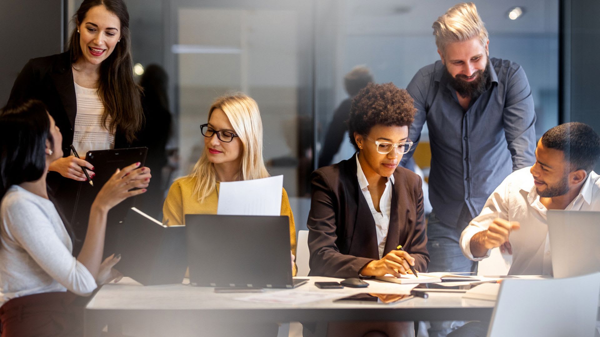 A group of individuals in an office, actively collaborating and exchanging ideas to enhance productivity and teamwork.