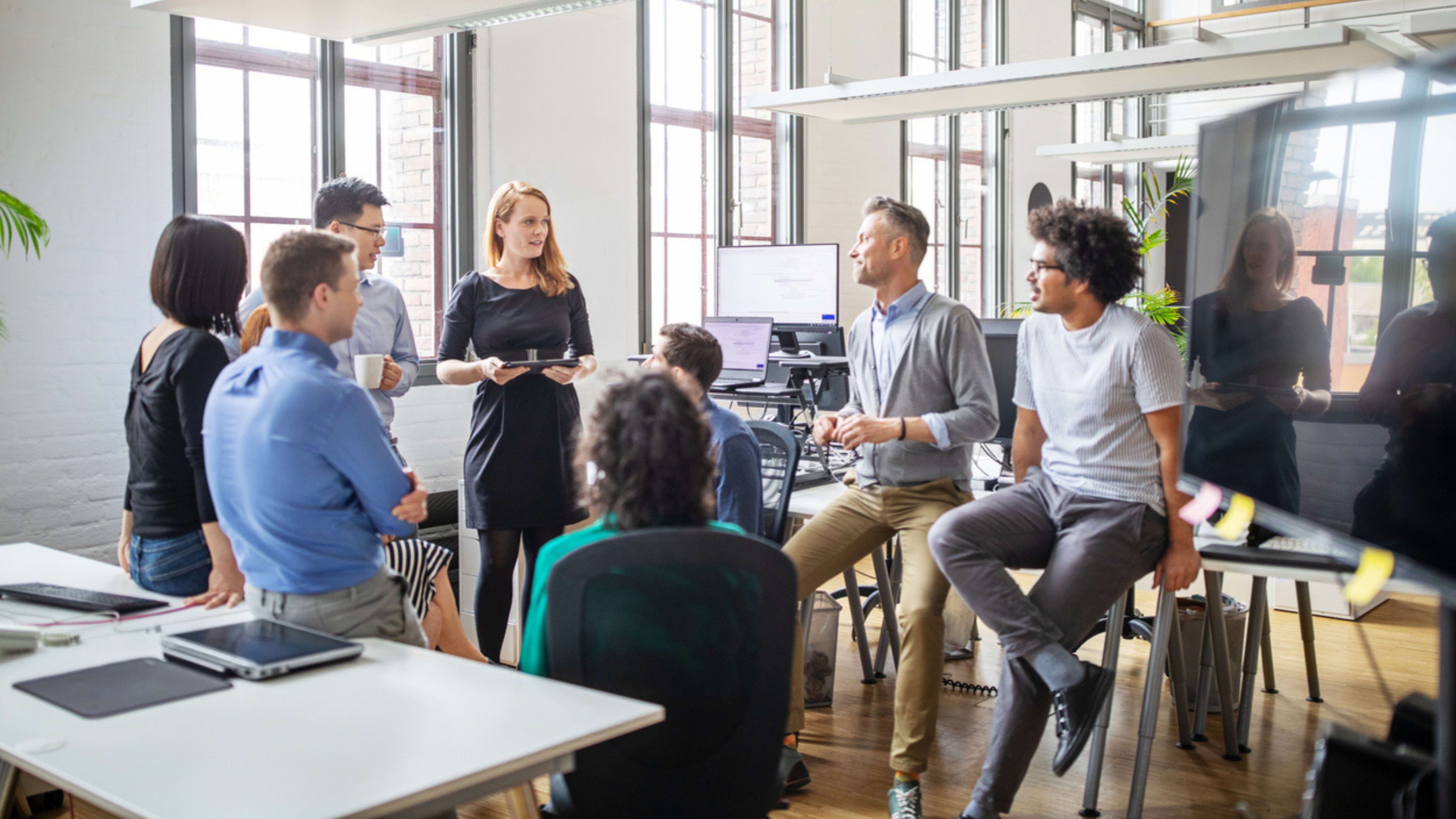 Several individuals collaborating at a table in an office, showcasing teamwork and communication in a professional environment.