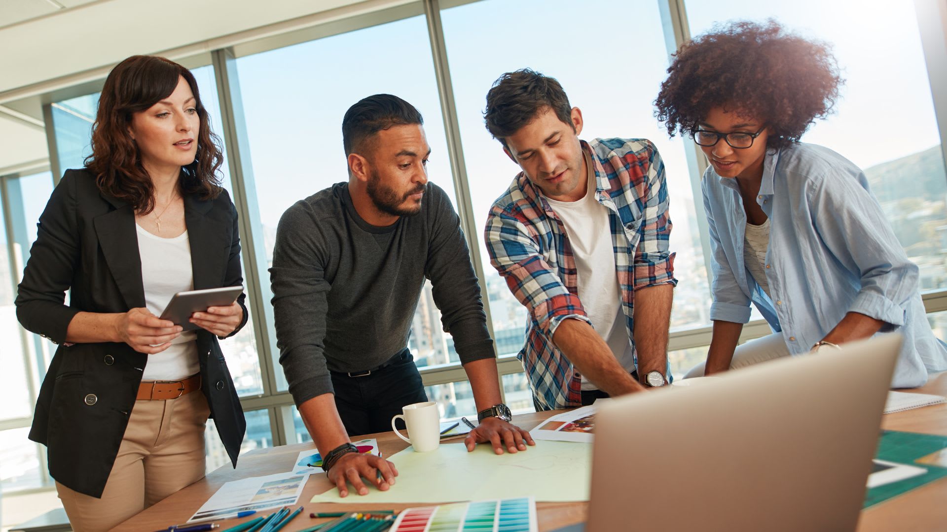A team of professionals engaged in a collaborative project, discussing and brainstorming ideas in a modern workspace.