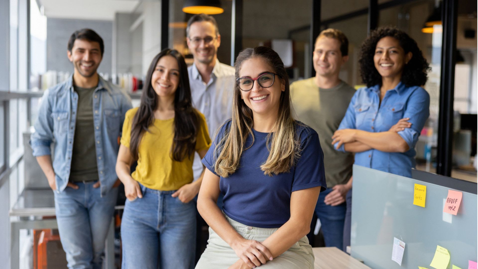 Happy group of workers smiling at the office while looking at the camera