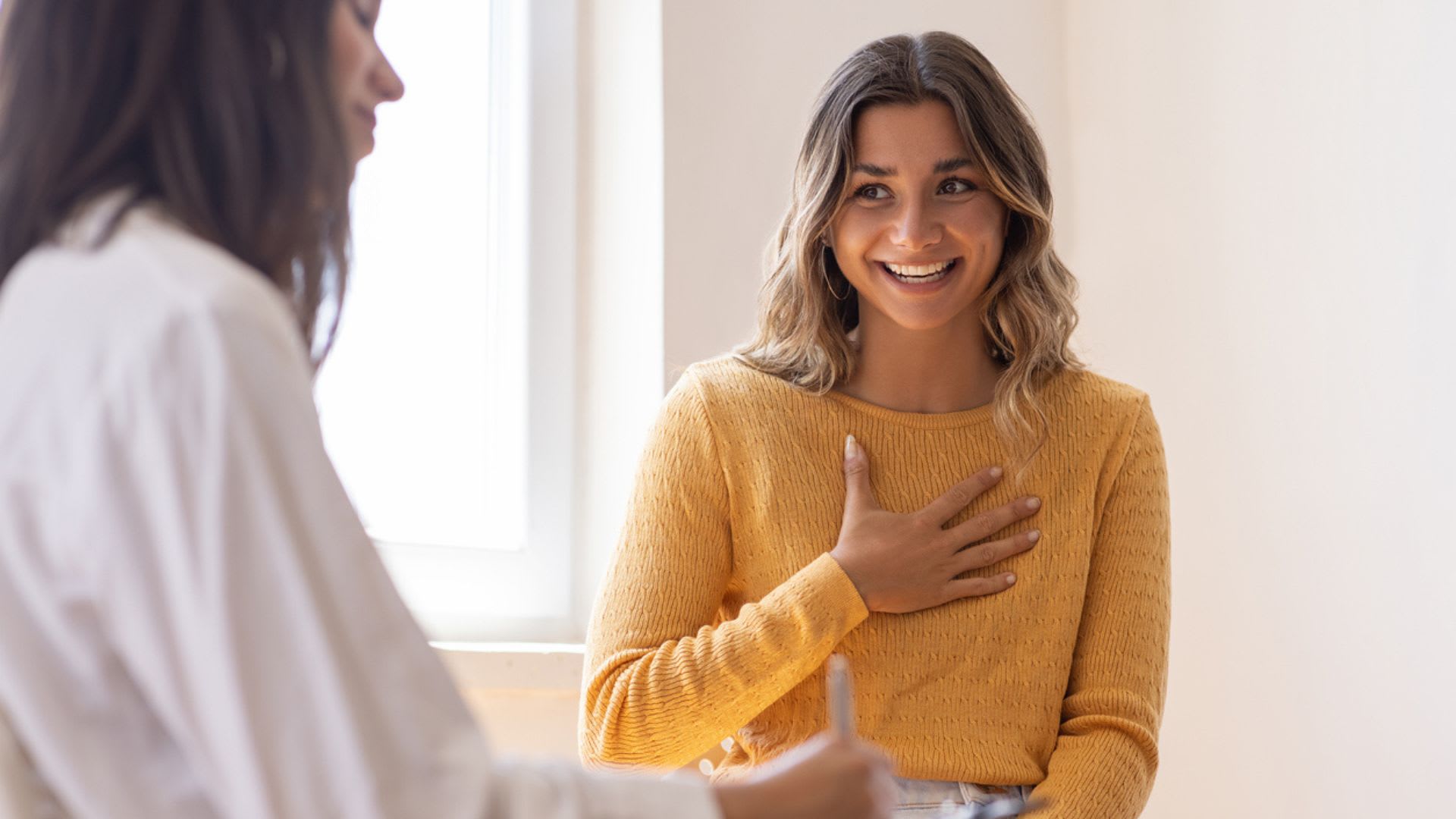 Woman speaking in a meeting sharing openly.