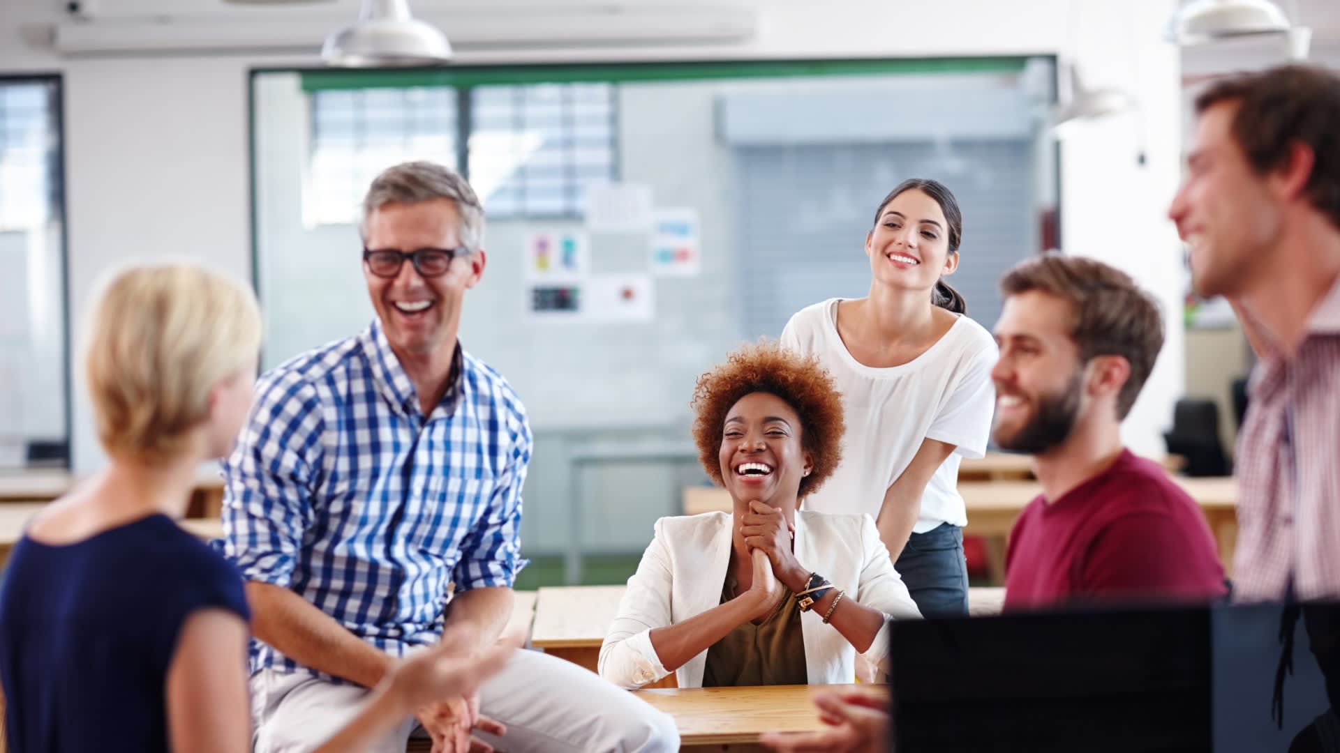 Several individuals collaborating at a table in an office, showcasing teamwork and communication in a professional environment.