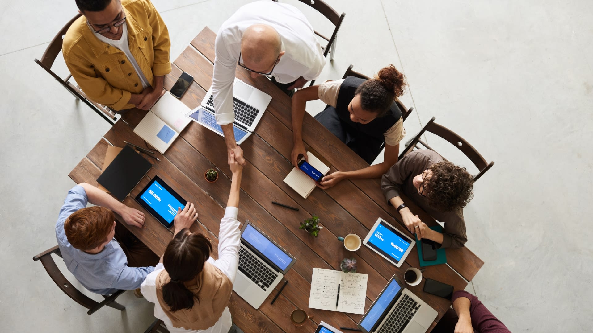 Several people seated at a table, focused on their laptops, fostering teamwork and collaboration in a modern workspace.