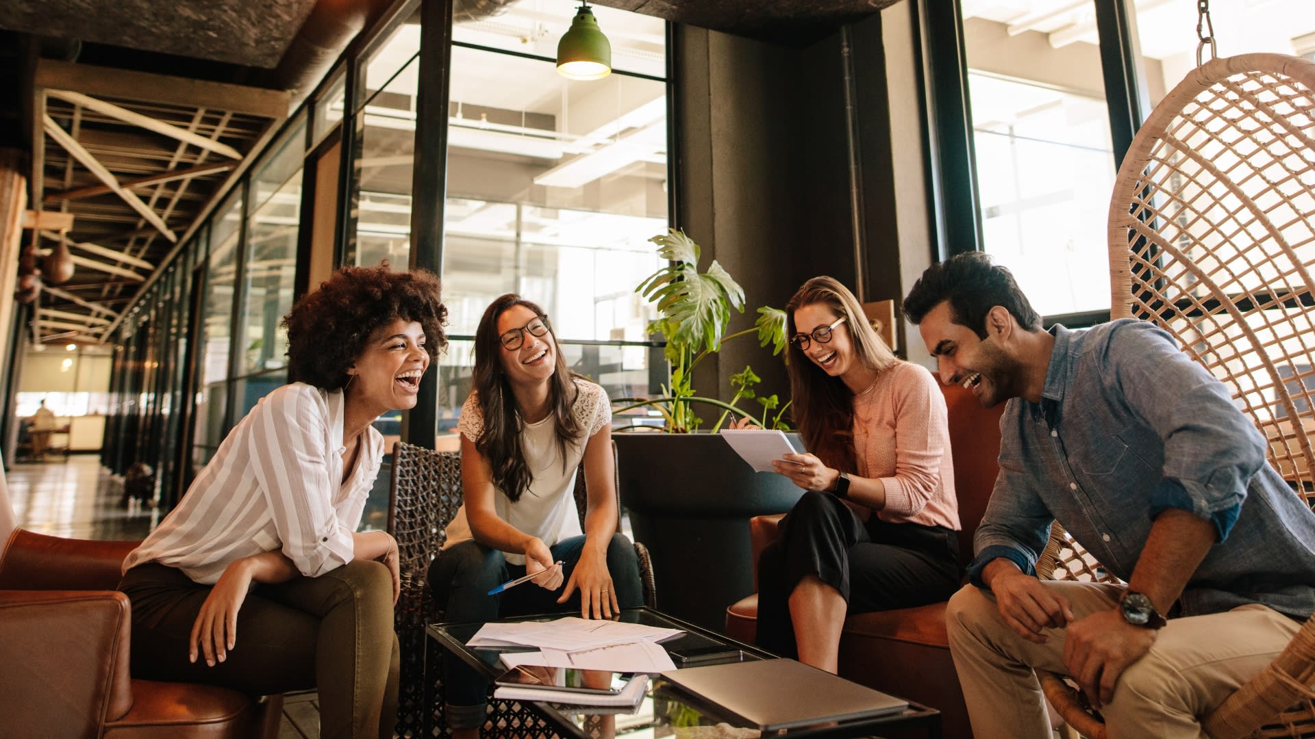 A group of people sitting on chairs in an office setting, likely collaborating or sharing ideas.