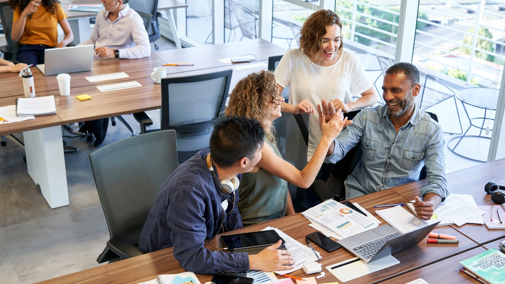 A diverse group of individuals collaborating at a table, each using laptops for a productive work session.