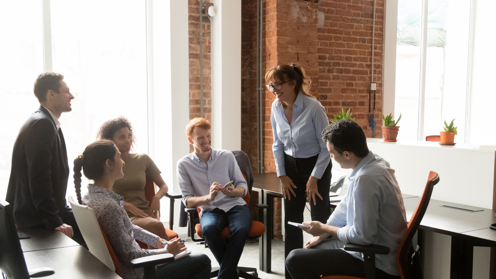 Several individuals collaborating at a table in an office, showcasing teamwork and communication in a professional environment.