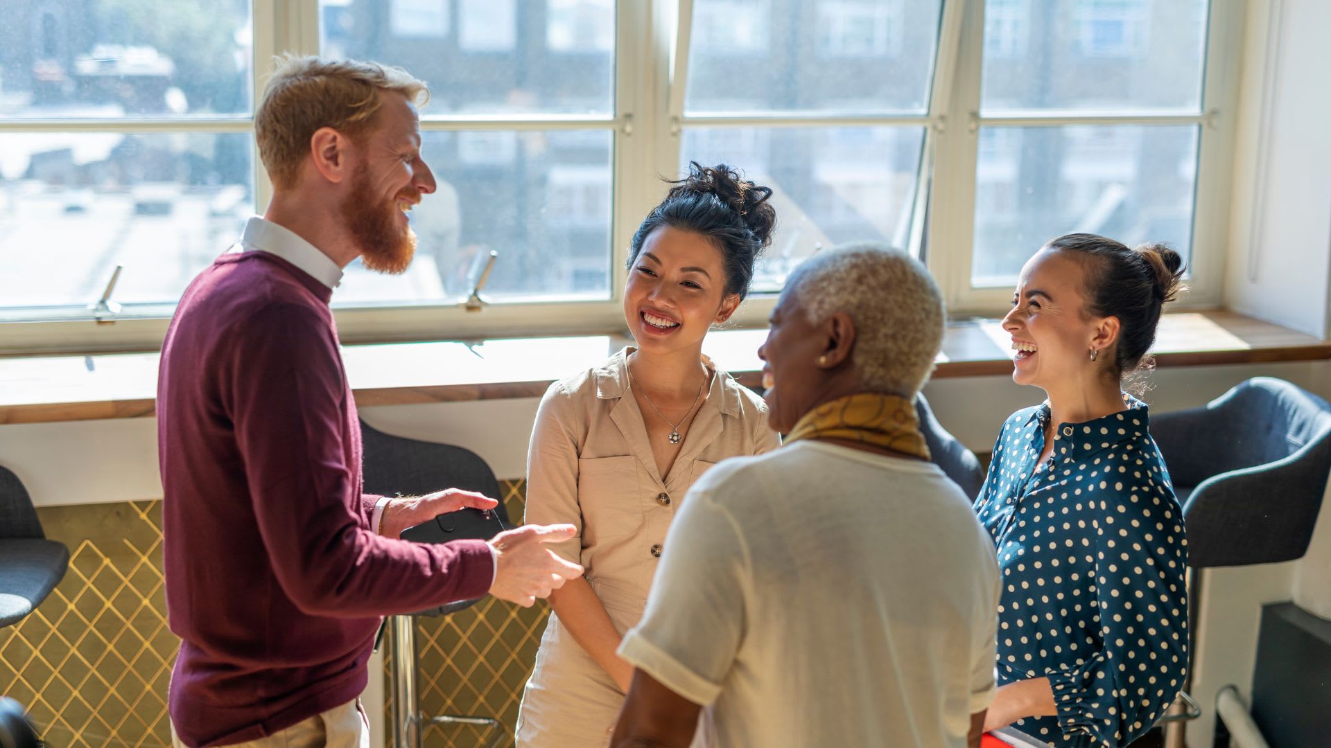 A team of professionals standing in an office, interacting and exchanging thoughts in a collaborative atmosphere.