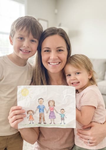 Sarah and her child holding artwork