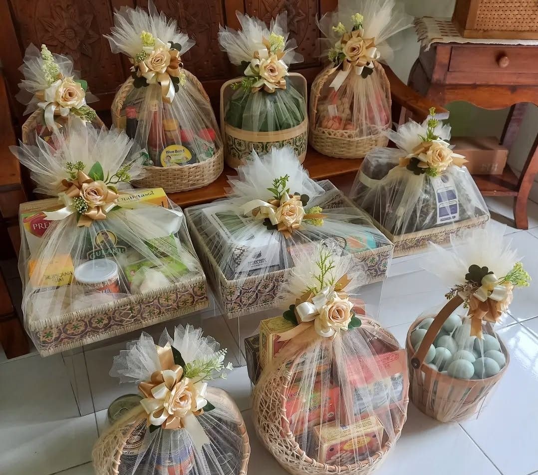 Tulle-wrapped wedding gift hampers in woven baskets