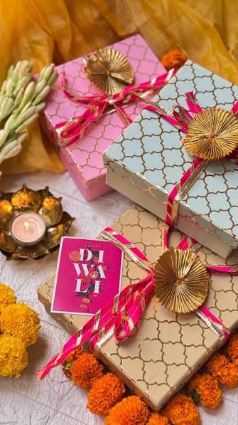 Pastel Diwali gift boxes with marigold flowers and diya