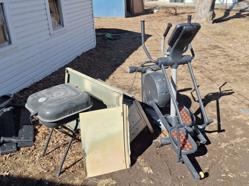 Elliptical machine, grill, and scrap metal items waiting for pickup by A1 Junk Removal and Tree Service in Omaha, NE
