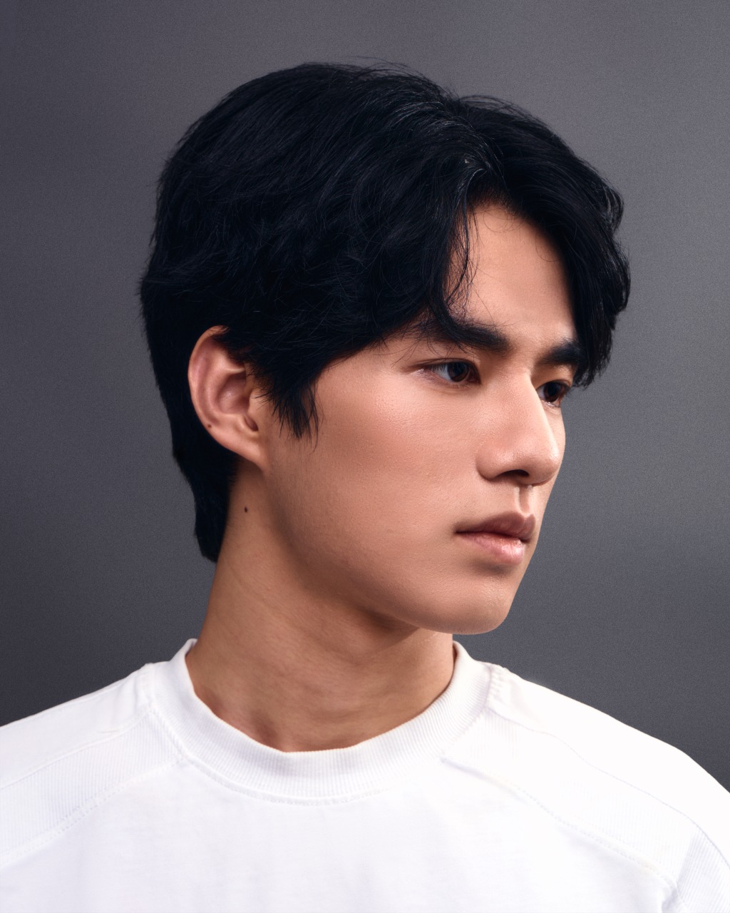 Studio headshot of a man in a white shirt against a grey background