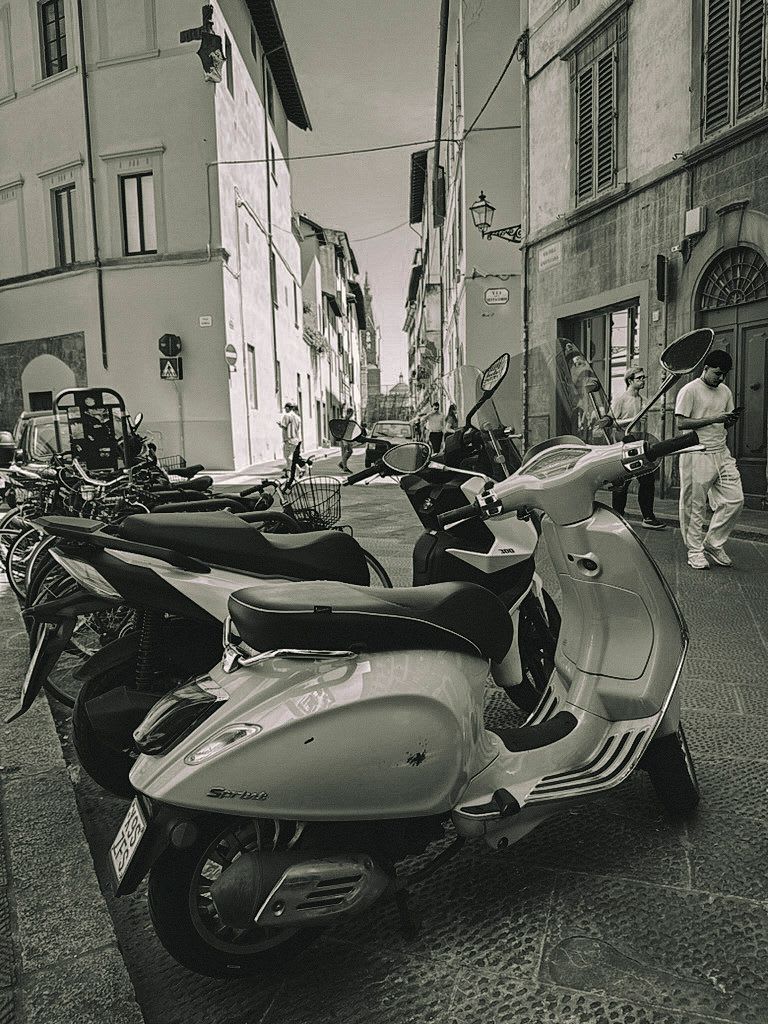 A Vespa parked on a Florence street, in black and white