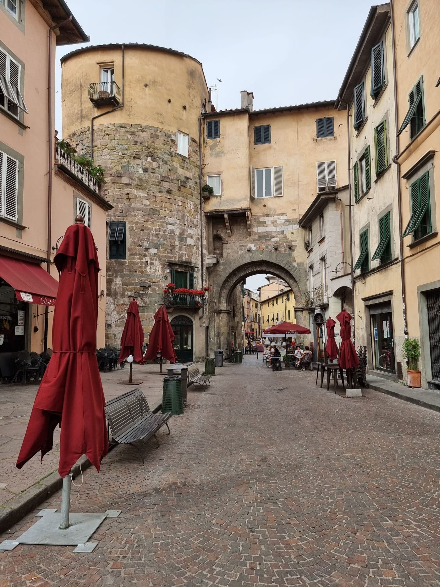 A street in Lucca's walled old town with a medieval tower behind