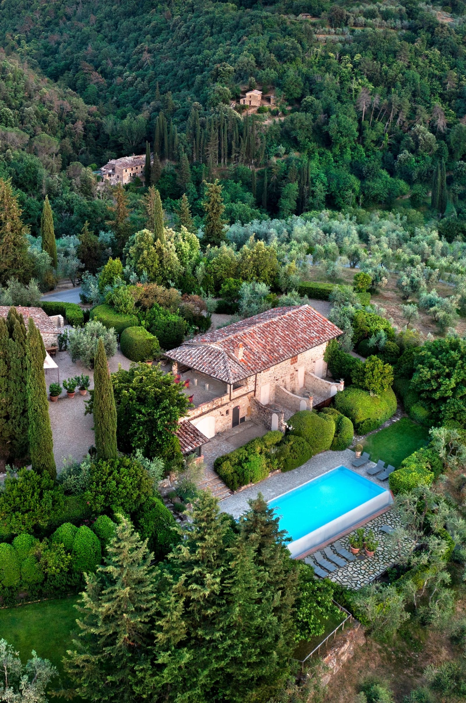 Casale Gherardi — aerial view of the stone farmhouses and pool among the olive groves