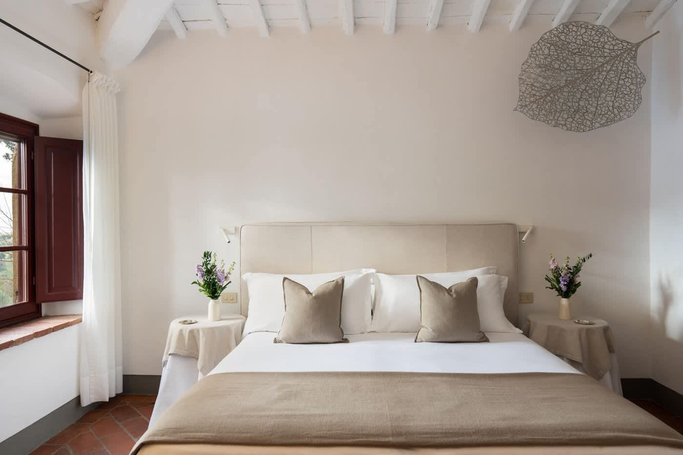 Villa Castellaro — a double bedroom with a cushioned headboard