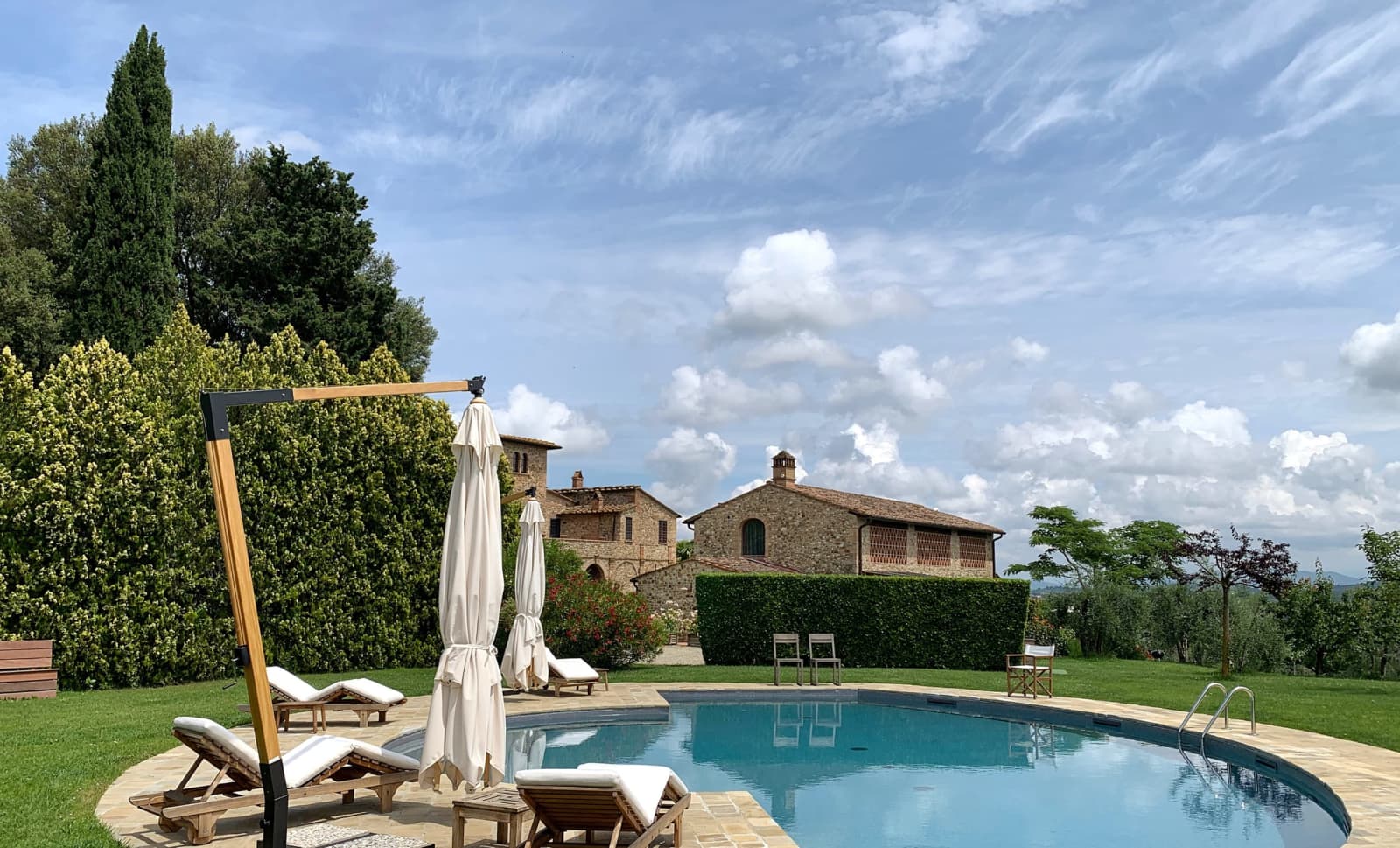 Casale Olivaio — the pool with the farmhouse beyond