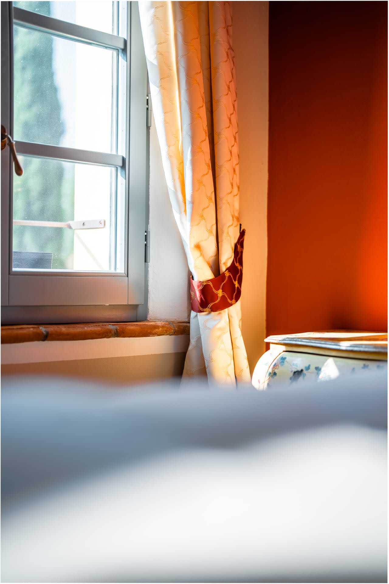 Villa Poggio d'Oro — morning light in a terracotta-walled bedroom