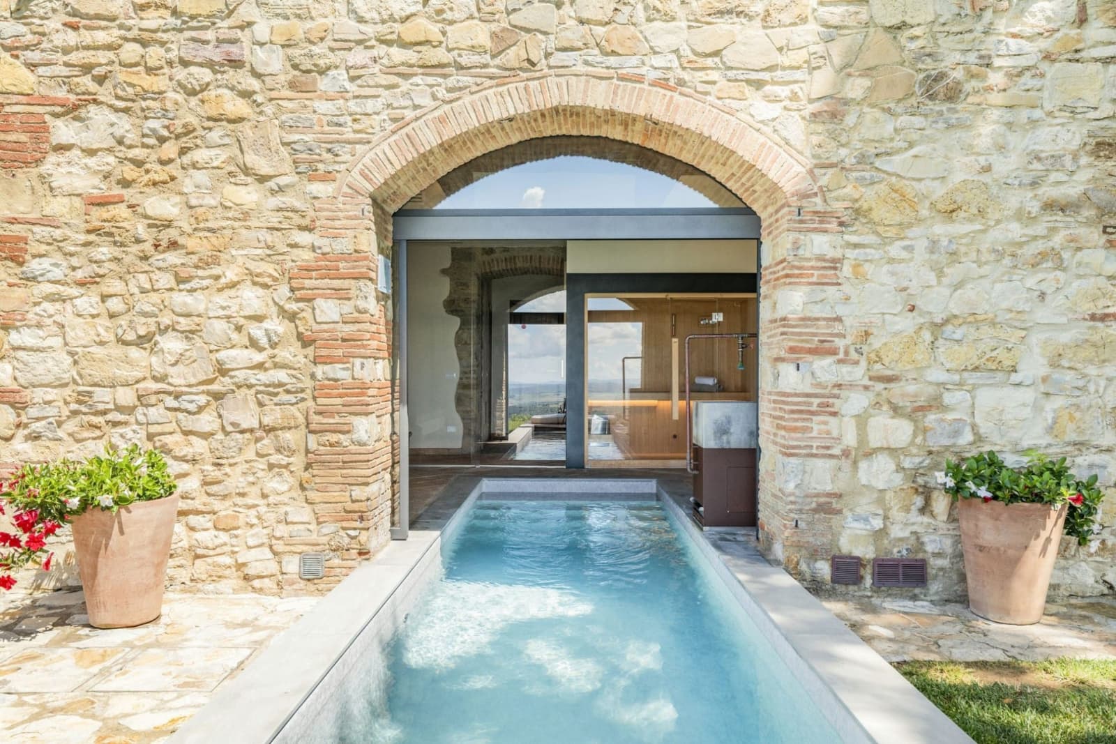 Villa Il Cellese — the pool swimming out through the stone arch