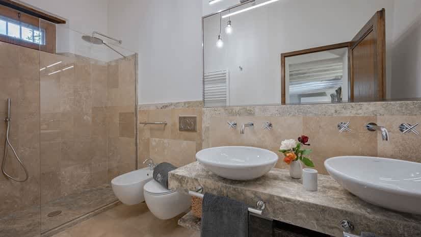 Borgo delle Vigne — a bathroom with a glass-walled shower and twin sinks