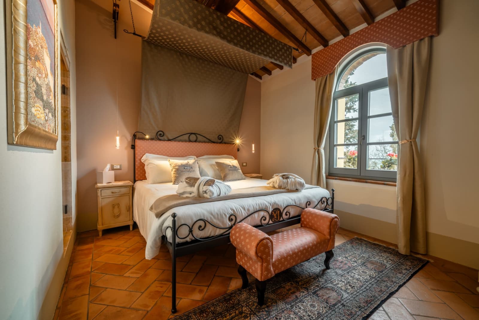 Villa Poggio d'Oro — a bedroom with a leather bench beneath the beams