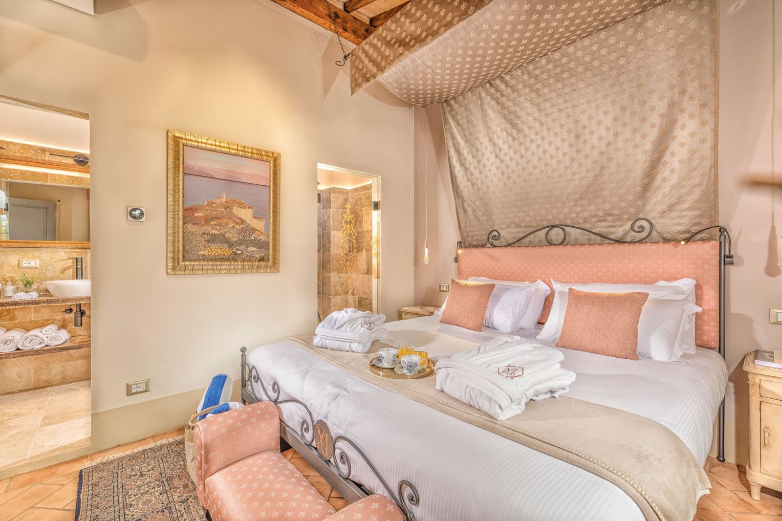 Villa Poggio d'Oro — a bedroom with a rose-pink headboard beneath the beams