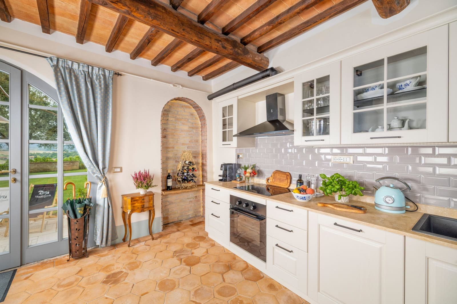 Villa Poggio d'Oro — a white kitchen with blue curtains