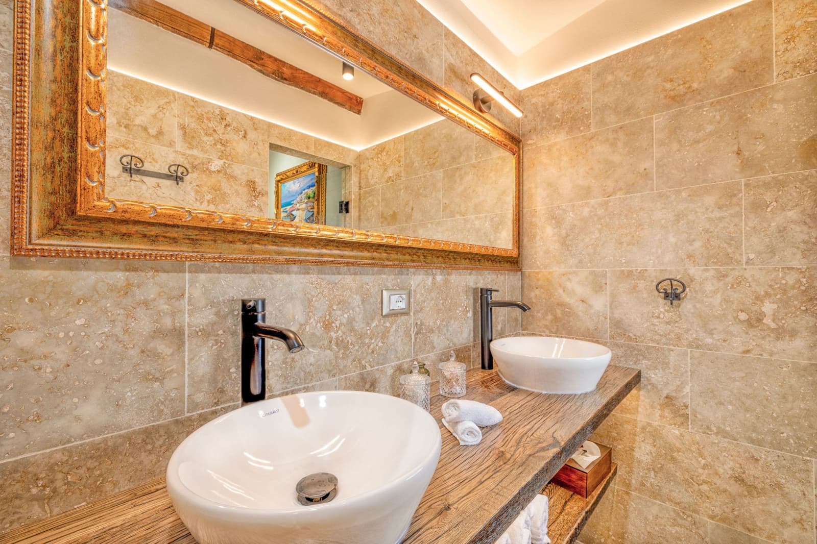 Villa Poggio d'Oro — a travertine bathroom with a mirrored vanity