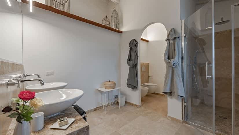 Borgo delle Vigne — a bathroom with an archway and bathrobes