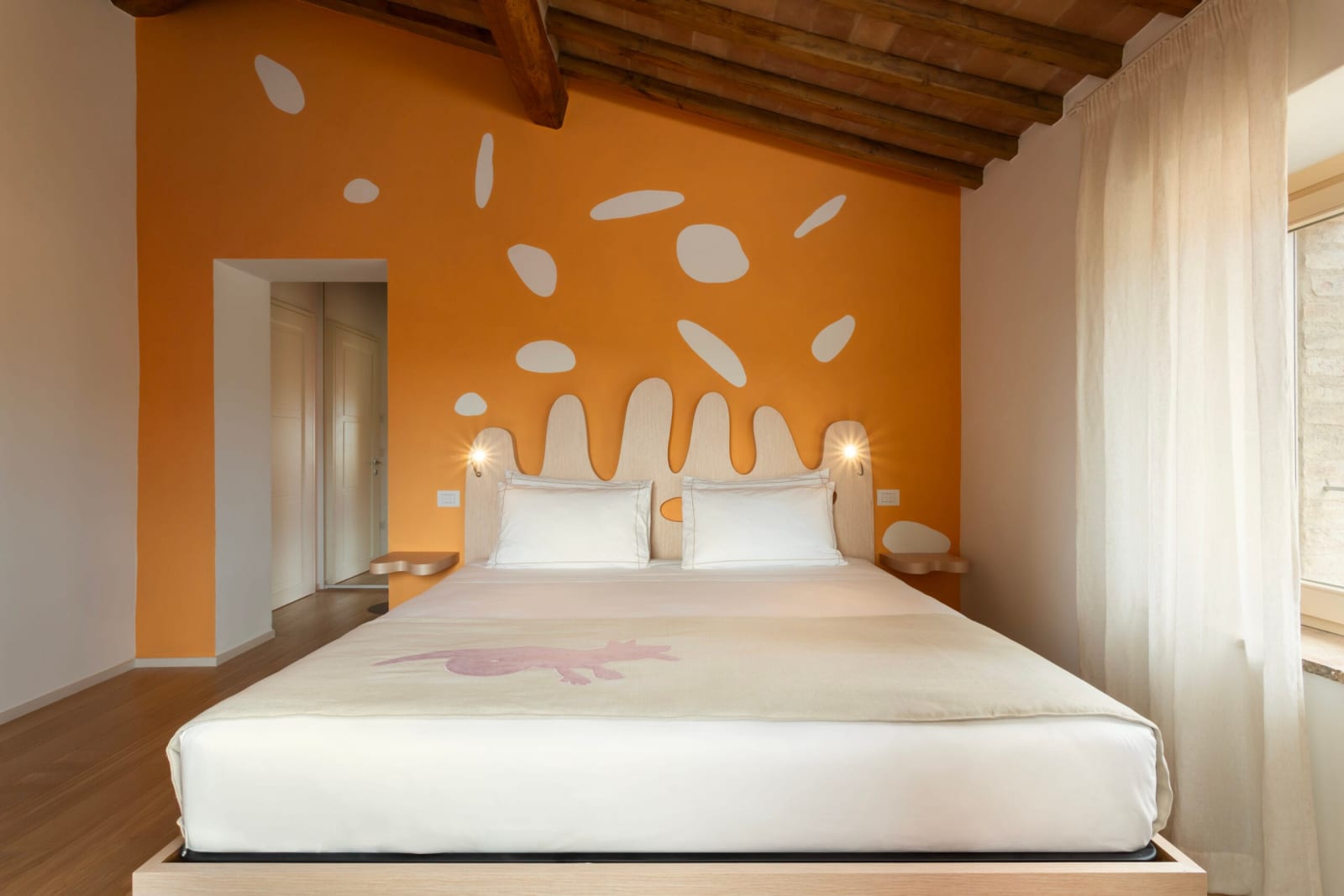 Podere Mastrojanni — a bedroom with an orange mural wall