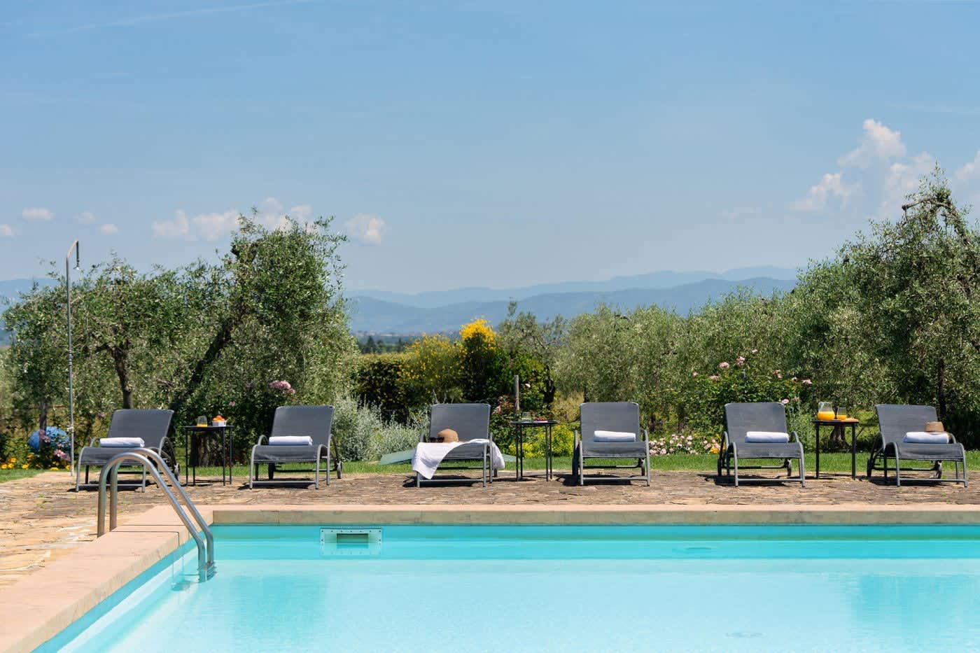 Villa Castellaro — loungers at the pool's edge, looking over the hills