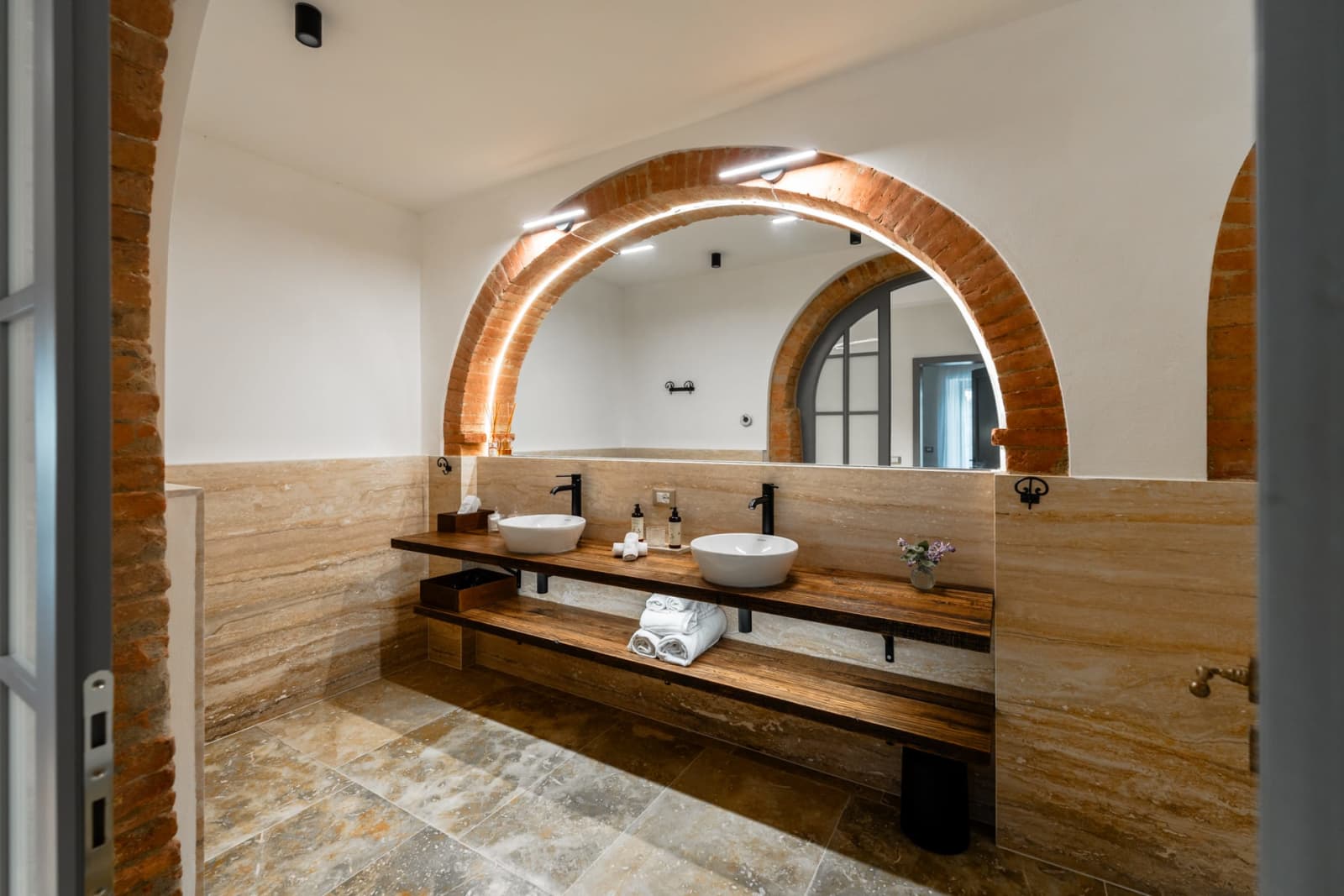 Villa Poggio d'Oro — a bathroom beneath a brick arch