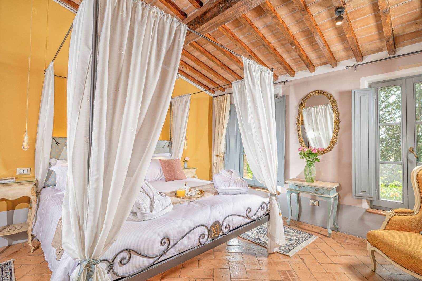 Villa Poggio d'Oro — a canopy bed against warm stone walls