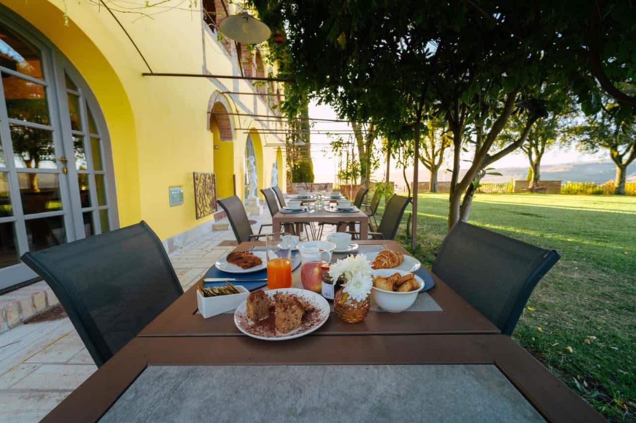 Villa Poggio d'Oro — breakfast tables along the garden front