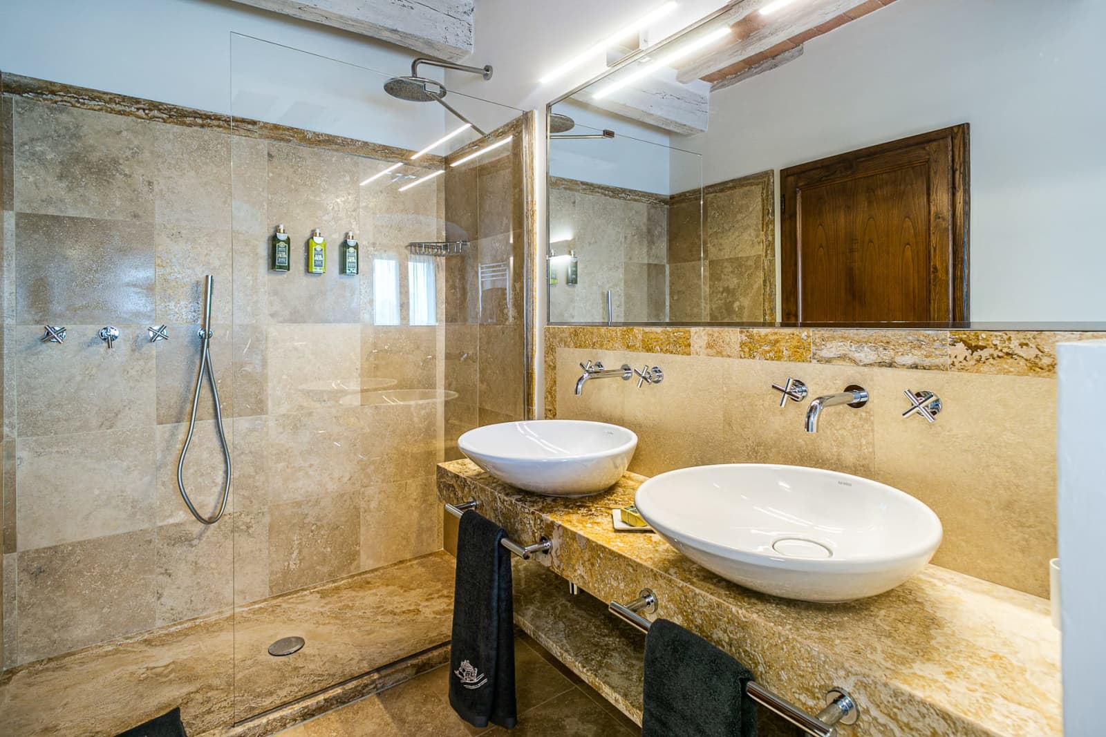 Casa dell'Erta — a travertine bathroom with twin basins