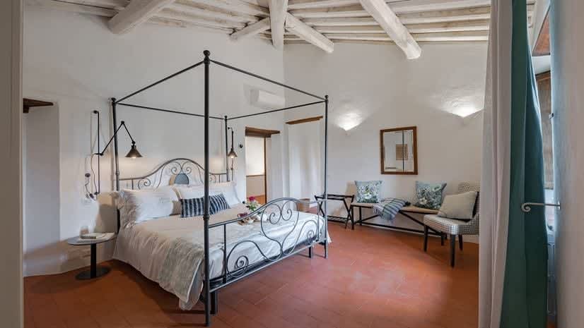 Borgo delle Vigne — a bedroom with an antique iron four-poster bed