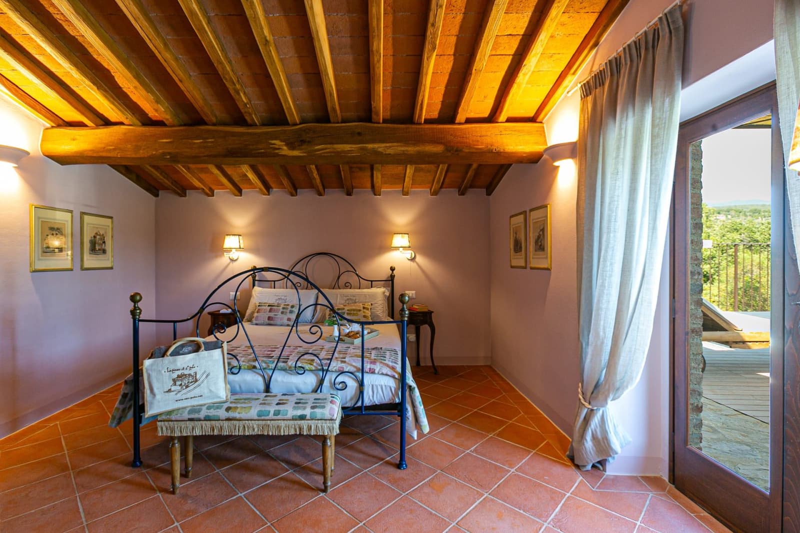 Casa Faraonia — a bedroom with a wrought-iron bed beneath the beams