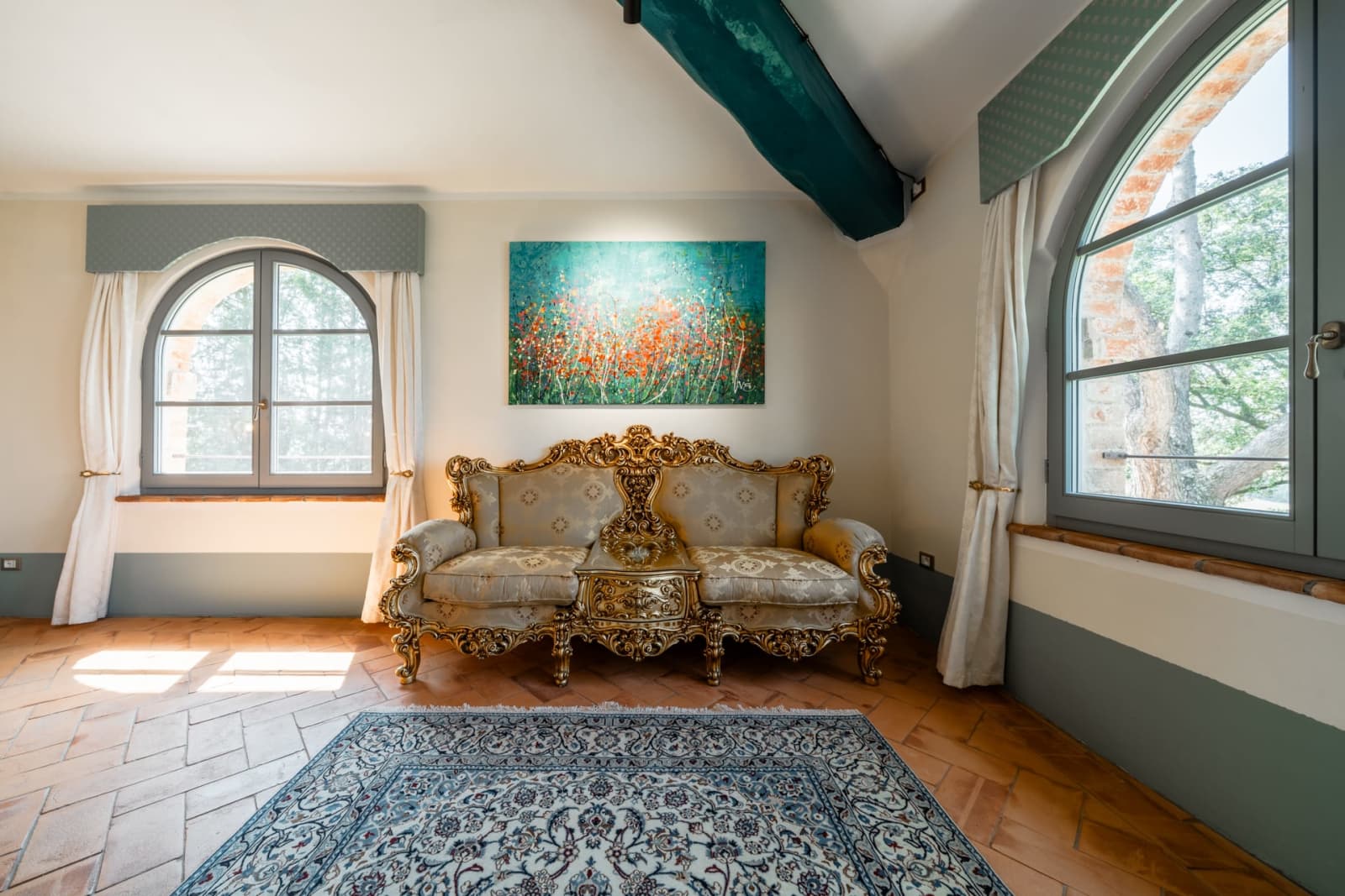 Villa Poggio d'Oro — a salon with a gilded sofa and a landscape painting
