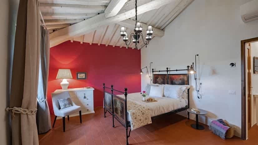 Borgo delle Vigne — a bedroom with a bold red feature wall