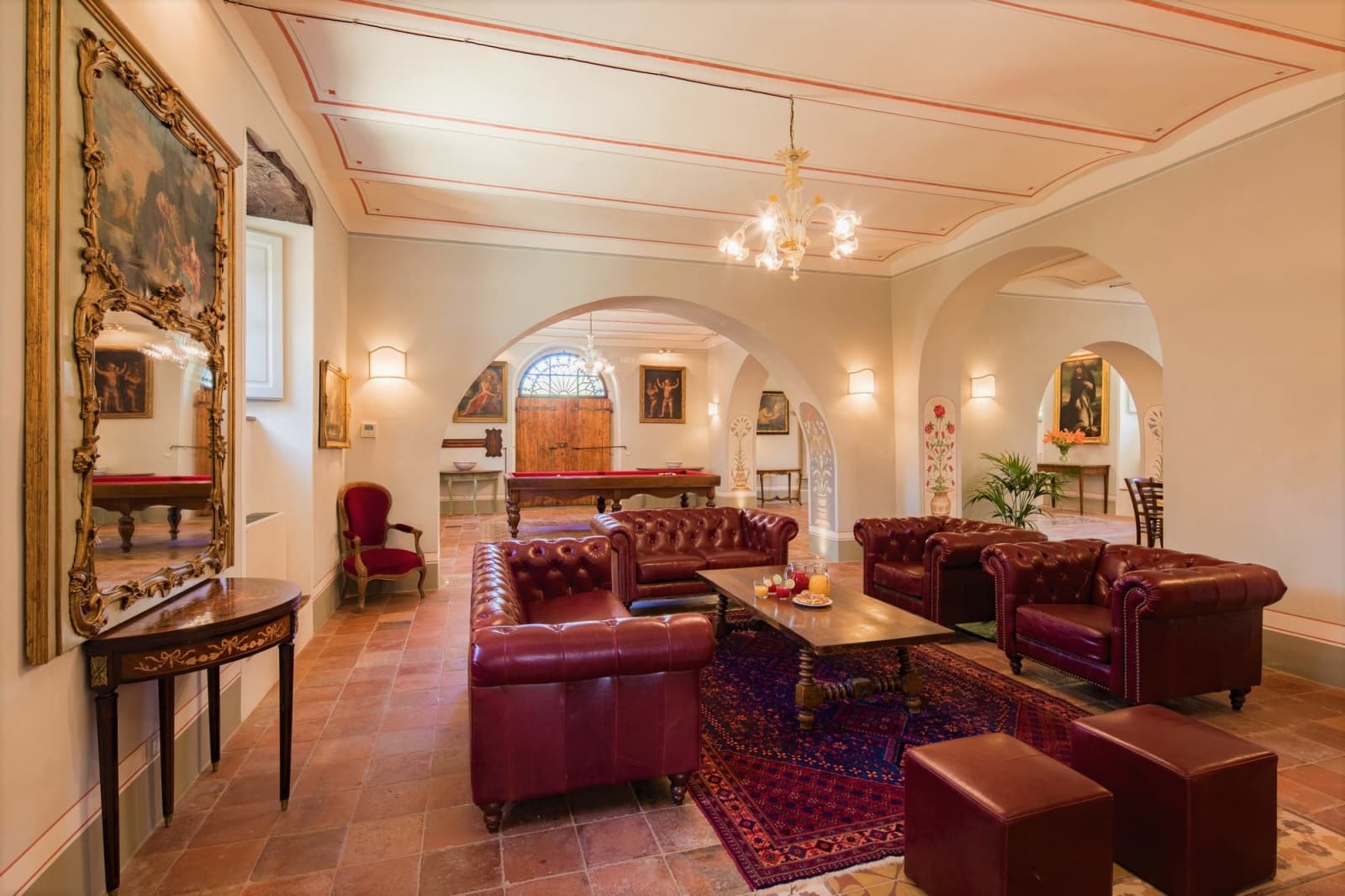 Villa della Cappella — the frescoed salon with billiards table and leather sofas