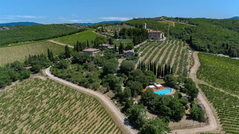 Borgo delle Vigne — an aerial view of the hilltop hamlet, with the pool and vineyards below