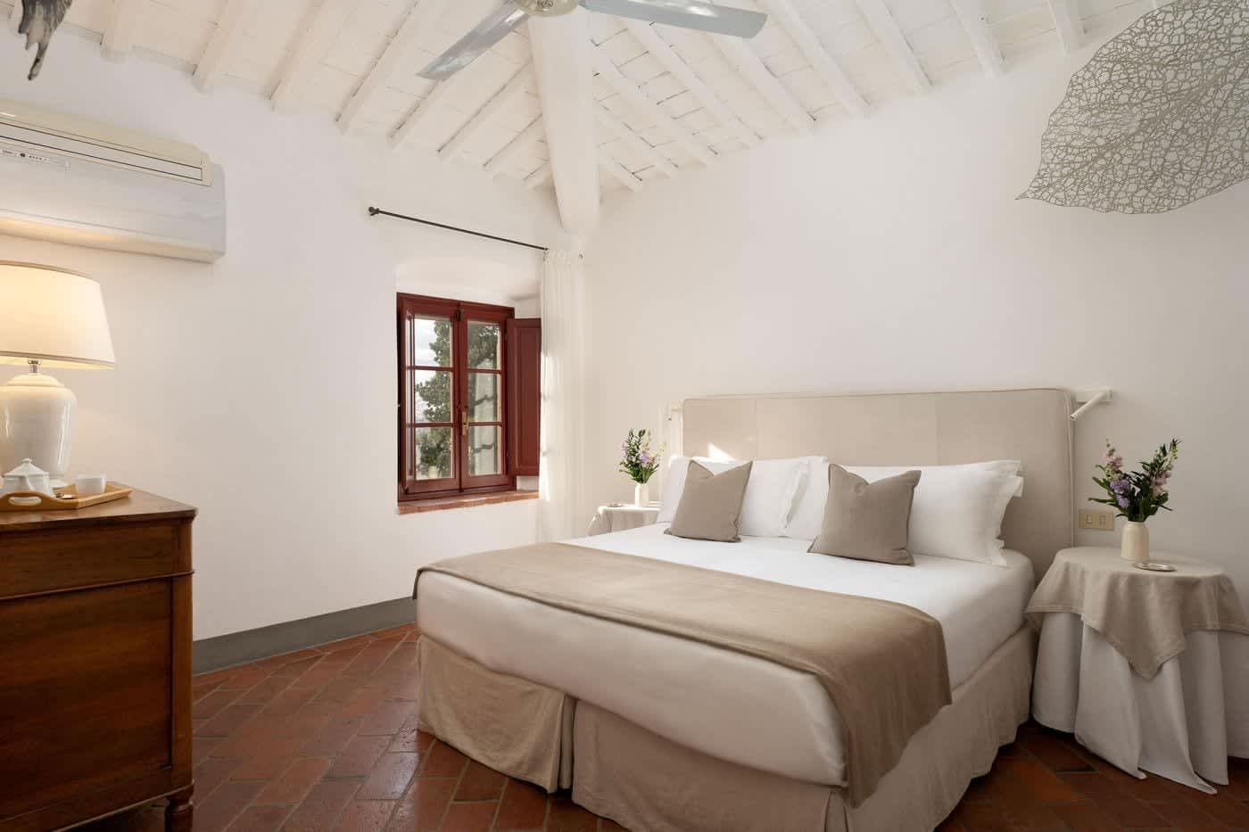 Villa Castellaro — a double bedroom beneath a beamed ceiling