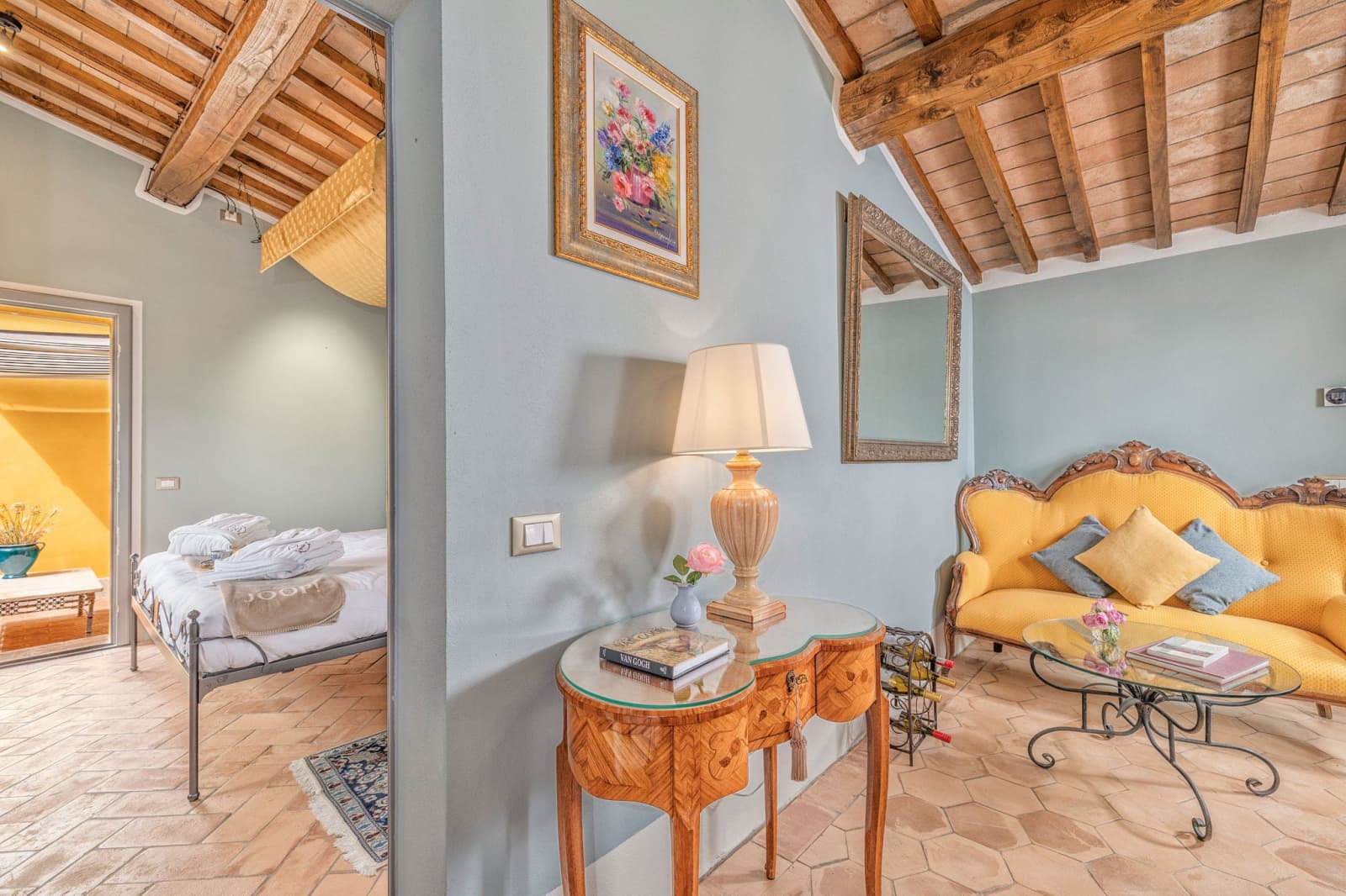 Villa Poggio d'Oro — a blue-walled sitting room with a yellow sofa