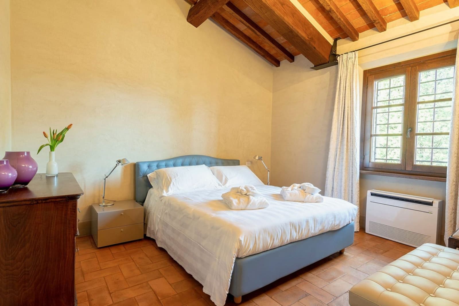 Villa San Bartolomeo — a bedroom with a blue tufted headboard