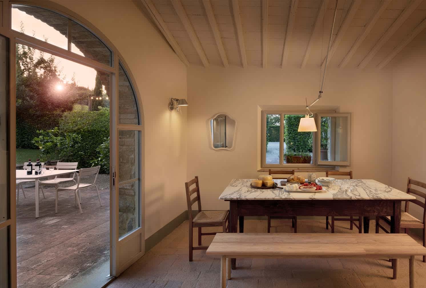Villa Erbavoglio — the farmhouse dining room opening to the terrace at sunset