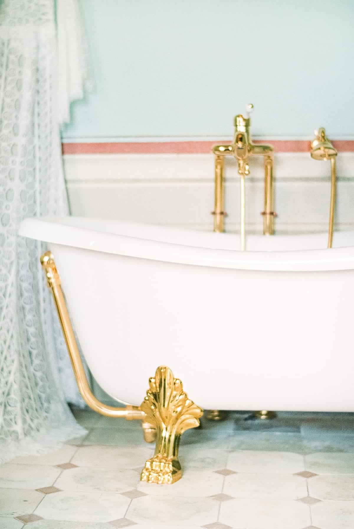 Villa della Cappella — a clawfoot bathtub with gold fixtures